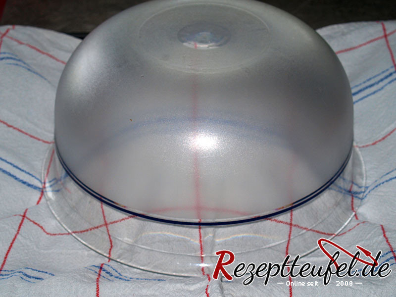 Der Teig unter einem Tuch und mit der Haube aus einer Schüssel