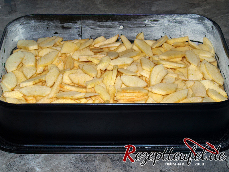 Die Apfelstücke auf dem Teig verteilen