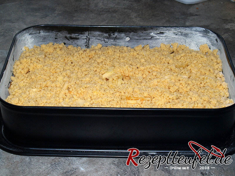 Die Streusel als Decke auf die Äpfel geben
