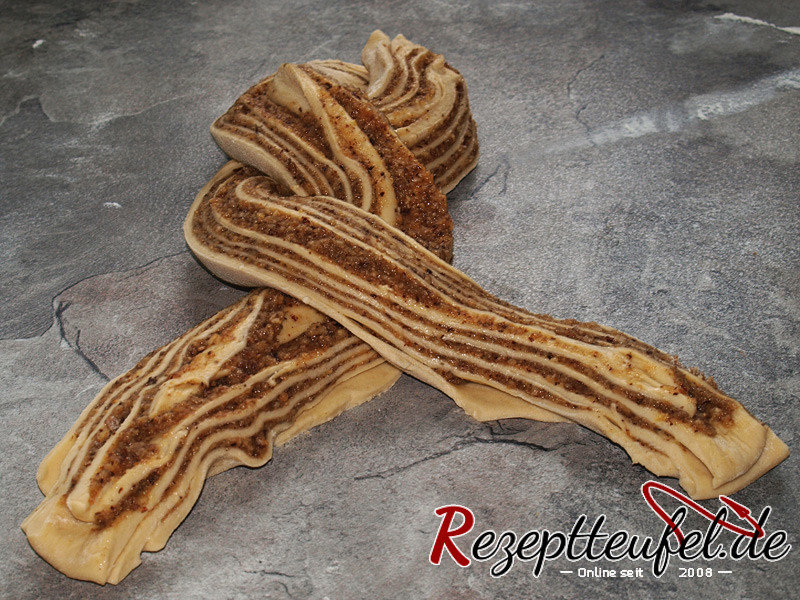 Die halben Teigrollen umeinander schlingen