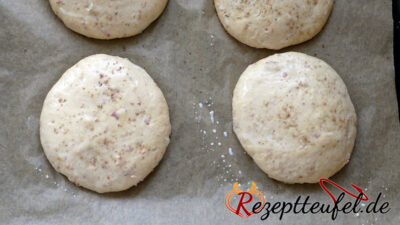 Aufgegangene Teiglinge mit Milch bestreichen und Salz bestreuen